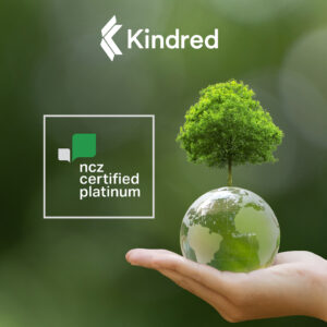 White Kindred logo at the top centre. On right a hand holding a glass earth globe with a tree on top. White box with NCZ platinum logo